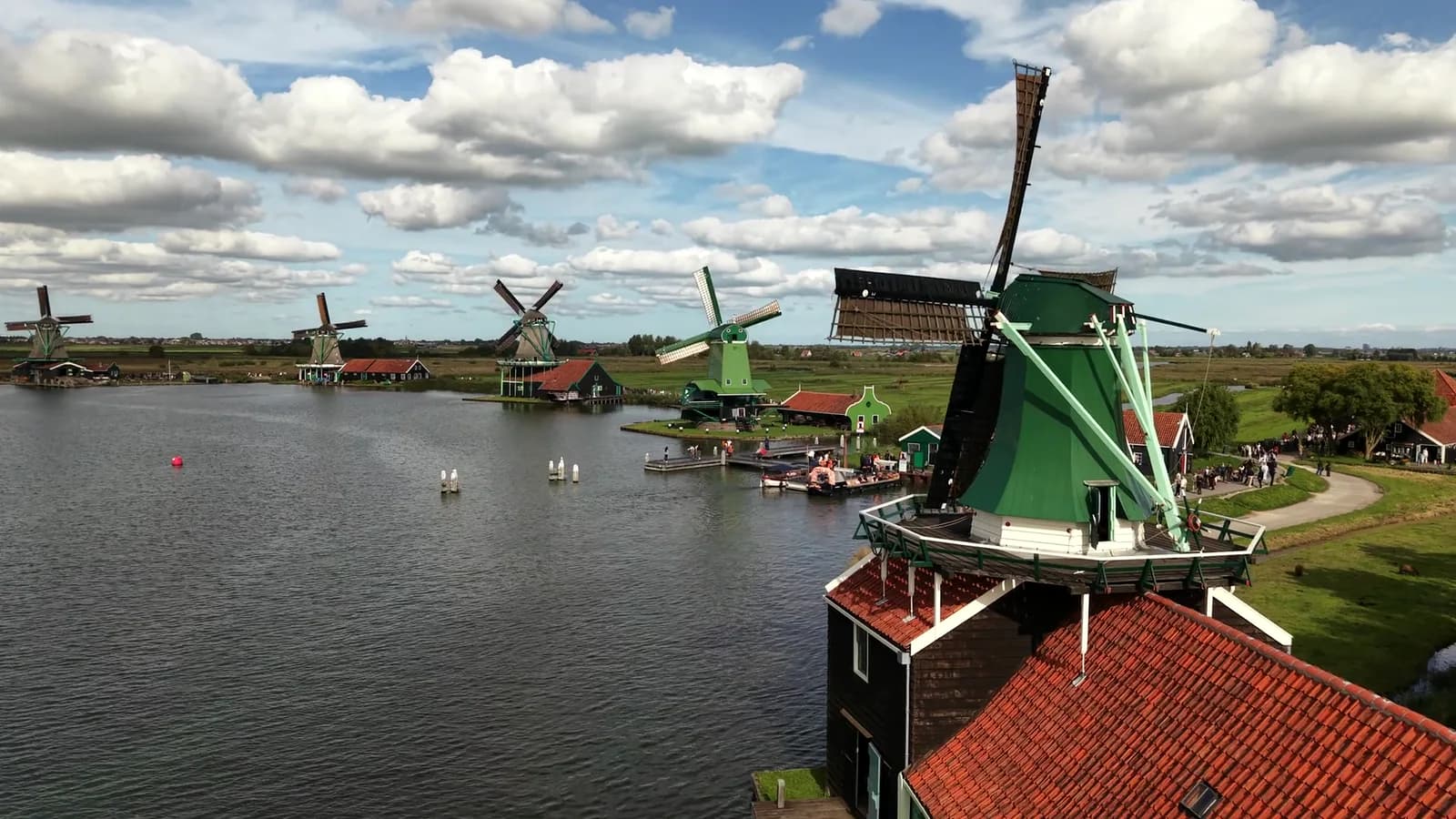 Aerial view of a green windmill, water and wooden houses at Zaanse Schans
